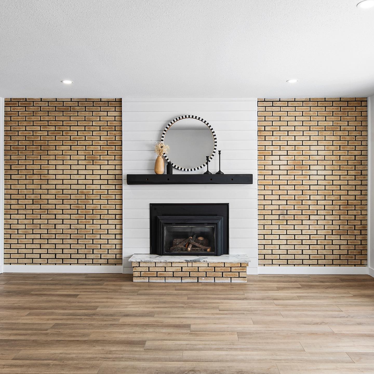 Renovated living space featuring original exposed brick and fireplace